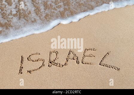 Inschrift Israel am Meer goldener Sandstrand gegen Wellenschaum. Urlaubskonzept. Stockfoto