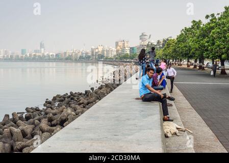 Mumbai, Indien - 22. November 2019: Die Menschen ruhen auf dem Marine Drive - EIN berühmtes Wahrzeichen in Mumbai, angezogen von vielen Touristen, die Indien besuchen. Stockfoto