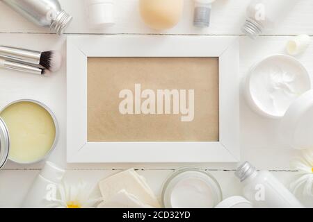 White Frame Set kosmetische Produkte in weißen Mockup Verpackung auf Holztisch Blumen, Kosmetiktasche. Schönheit Hautpflege Haarbehandlung kosmetische Stockfoto