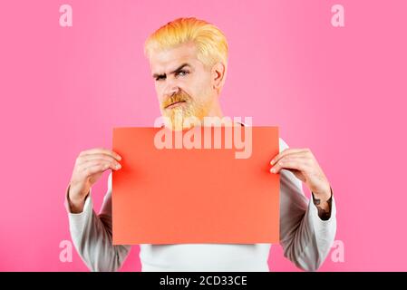 Ernst kaukasischen blonde männliche Modell posiert in Mode Konzept Studio schießen. Mann Arbeiter hält Werbung Red Board. Stockfoto