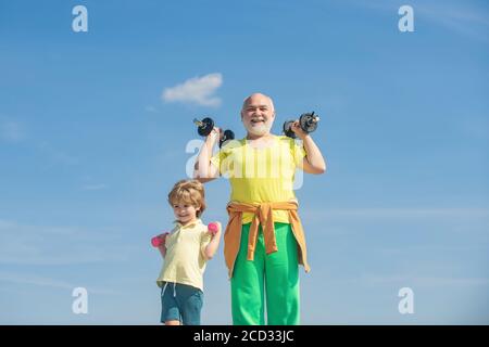 Großvater und Enkel mit Hanteln in den Händen. Sport zu treiben ist kostenlos. Gesunder Familienleben. Sportliche Familie mit Hanteln. Wie Sport. Stockfoto