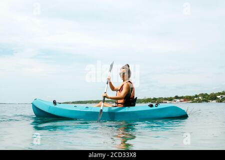 Glückliche junge und schöne Frau Kajak auf dem See Stockfoto