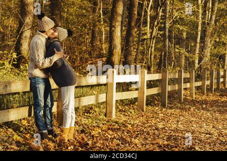 Junges Paar Tragen warme Pullover und Wolle Hüte im Park am sonnigen Herbsttag Stockfoto