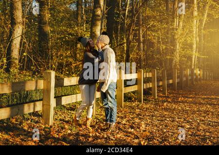 Junges Paar Tragen warme Pullover und Wolle Hüte im Park am sonnigen Herbsttag Stockfoto