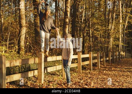 Junges Paar Tragen warme Pullover und Wolle Hüte im Park am sonnigen Herbsttag Stockfoto