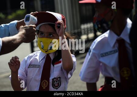 (200826) -- JAKARTA, 26. August 2020 (Xinhua) -- eine elementare Studentin mit Gesichtsmaske lässt ihre Temperatur überprüfen, bevor sie während des COVID-19-Ausbruchs in Jakarta, Indonesien, am 26. August 2020 einen Masern-Röteln-Impfstoff (MR) erhält. Masern-Röteln (MR)-Impfstoffe werden Kindern als Teil des Programms der indonesischen Regierung verabreicht, um Schulkindern eine angemessene Immunisierung zu bieten. (Xinhua/Agung Kuncahya B.) Stockfoto