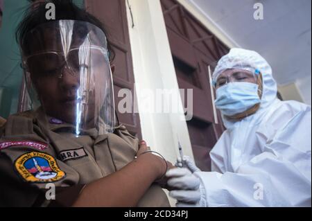 (200826) -- JAKARTA, 26. August 2020 (Xinhua) -- ein elementarer Student mit Gesichtsschutz erhält einen Masern-Röteln-Impfstoff (MR), der von einem Gesundheitsbeauftragten während des COVID-19-Ausbruchs in Jakarta, Indonesien, am 26. August 2020 durchgeführt wird. Masern-Röteln (MR)-Impfstoffe werden Kindern als Teil des Programms der indonesischen Regierung verabreicht, um Schulkindern eine angemessene Immunisierung zu bieten. (Xinhua/Agung Kuncahya B.) Stockfoto