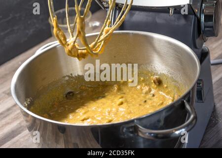 Teig für Muffins in der Rührschüssel auf der Küchenunterseite - roher Teig Stockfoto