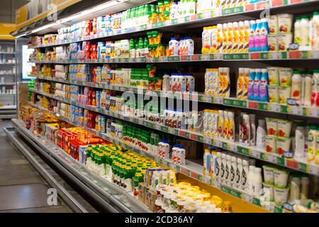 Moskau, Russland - 23. August 2020: Regal mit Milchprodukten in einem Supermarkt. Mehrfarbige Gläser mit Sauerrahm, Joghurt, Quark und Milch. Lar Stockfoto