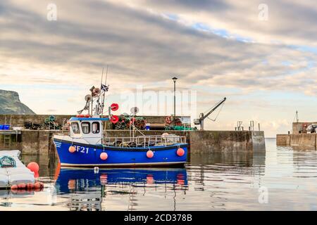 GARDENSTOWN, SCHOTTLAND - 2016. OKTOBER 22. Kleines blaues Fischerboot im Gardenstown Hafen. Stockfoto