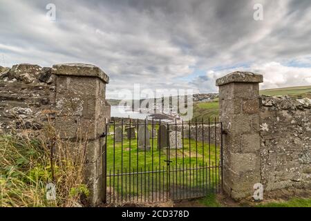 GARDENSTOWN, SCHOTTLAND - 2016. OKTOBER 22. St. John's Church und Kirkyard mit Blick auf Gardenstown Dorf. Stockfoto