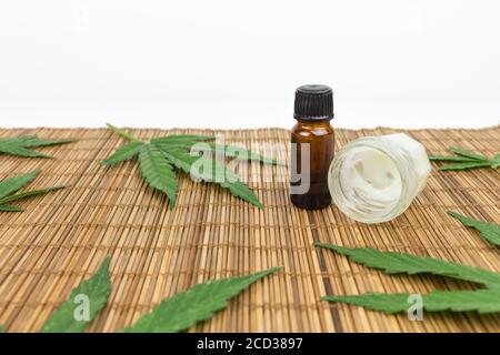 CBD-Öl und Creme mit Marihuana-Blättern auf einem Stock Tischdecke Stockfoto