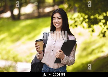 Lächelnd Asiatisch Student Mädchen Mit Rucksack Und Laptop Genießen Takeaway Kaffee Im Freien Stockfoto