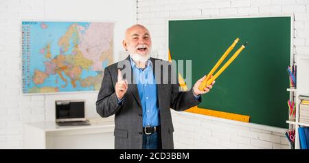 Schau dir das an. Zurück zur Schule. Mathematische Grafik-Tools Konzept. In Richtung Wissen. Studieren Sie Mathematik, um gute Ergebnisse zu erhalten. Senior man Lehrer verwenden Kompass-Werkzeug. Bärtiger Tutor Mann zeichnen mit Kompass auf Tafel. Stockfoto