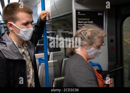 Bahnreisende auf einem Zugverkehr durch Süd-London tragen Gesichtsbezüge während der Coronavirus-Pandemie am 24. August 2020 in London, England. Stockfoto