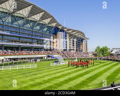 Guardmen in roten Uniformen spielen im Parade Ring und unterhalten die Menge während Royal Ascot, Ascot Racecourse, Ascot Berkshire Stockfoto