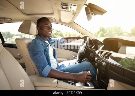 Glücklich schwarz Kerl Auto fahren, innen erschossen Stockfoto