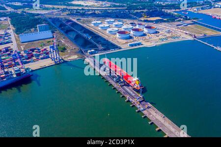 Laden Kohle Anthracite Mining im Hafen auf Cargo tanker Schiff mit Kran Eimer von Zug. Antenne Ansicht von oben. Stockfoto