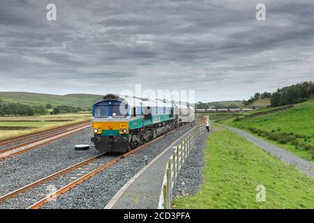 GB Railfreight Baureihe 66 Lokomotive 66711 mit Zuschlagzug vom Gleis in Arcow Quarry, Yorkshire. Stockfoto