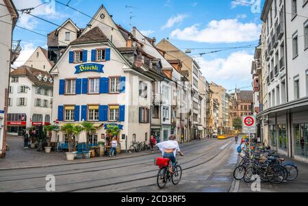 Basel Schweiz , 29 Juni 2020 : Frau auf einem Fahrrad und Straßenbahn und alten Häusern Straßenansicht in Basel Altstadt Schweiz Stockfoto