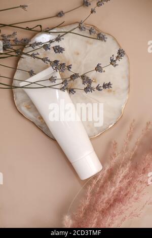 Weiße Kosmetikröhre auf hellem pfirsichfarbenem Hintergrund. Natürlicher Minimalismus, sauberes nachhaltiges Konzept. Minimale Styling-Szene, Stillleben. Beauty Blogging Stockfoto