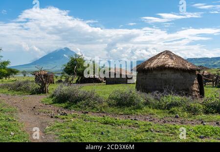 Traditionelles Maasai Dorf mit Tonrundhütten in Engare Sero Gebiet in der Nähe von Lake Natron und Ol Doinyo Lengai Vulkan in Tansania, Afrika Stockfoto