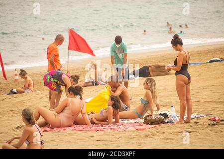 Las Palmas, Gran Canaria, Kanarische Inseln, Spanien. August 2020. Touristen am Stadtstrand in Las Palmas auf Gran Canaria. Mit Covid 19 Fällen steigt auf Gran Canaria, hat die lokale Regierung verboten Joggen auf der Strandpromenade während des Tages sowie Sonnenbaden am Strand bei Flut zu verhindern, dass Gedränge. Im August wurden auf Gran Canaria mehr neue Coronavirus-Fälle registriert als in den Monaten März bis August zusammen. Mehr als 100 der neuen Fälle wurden auf eine Disco in der Hauptstadt Las Palmas zurückgeführt. Kredit: Alan Dawson/Alamy Live Nachrichten Stockfoto