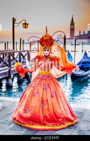 Venedig, Italien, venezianisches Maskenmodell aus dem Karneval von Venedig, mit Gondeln im Hintergrund, Canal Grande Stockfoto