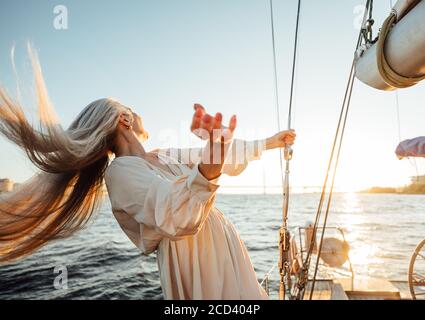 Unkenntlich reife Frau mit langen Haaren Spaß auf einem yacht und Blick auf den Sonnenuntergang Stockfoto