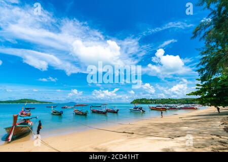 Reisen Sie langjährigem Holzboot auf dem weißen Strand türkisfarbenes Wasser in Phuket, Thailand. Phuket ist ein beliebtes Reiseziel, das für seine Strände bekannt ist. Stockfoto