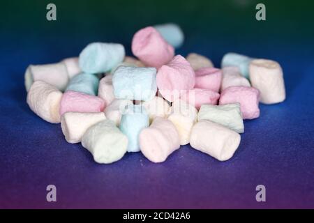 Nahaufnahme eines Stapels von bunten Marshmallows auf einem Blauer Hintergrund Stockfoto