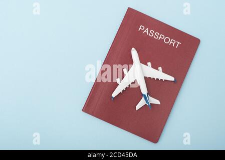 Flugzeug auf dem Cover des roten Passes. Reisekonzept. Blauer Hintergrund Stockfoto