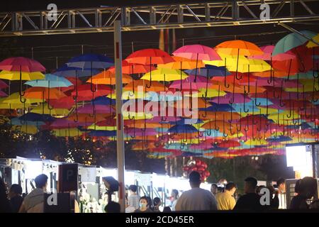 Ein Korridor, der mit bunten Regenschirmen geschmückt ist, soll den Nachtmarkt in Shenyang City, nordöstlich der Provinz Liaoning, am 25. Juli ankurbeln Stockfoto