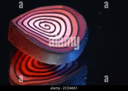 Nahaufnahme von rotem und weißem Lollipop auf schwarzem Hintergrund Stockfoto