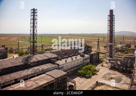 Verlassene Metallurgie Fabrikgebäude und verrostete Fabrikschornsteine auf dem blauen Himmel, Steppe und Berg Hintergrund. Taraz Stadt. Stockfoto