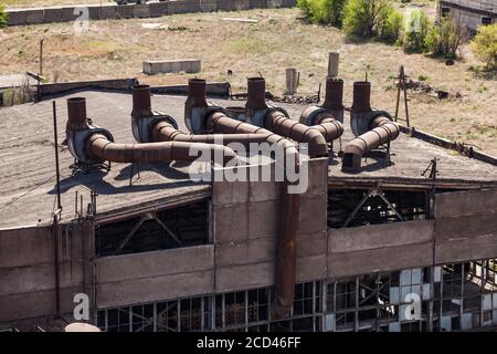 Altes, nicht gebrauchter sowjetischer Metallurgie-Fabrikgebäude mit verrosteten Lüftungsrohren und kaputten Fenstern. Taraz Stadt, Kasachstan. Stockfoto