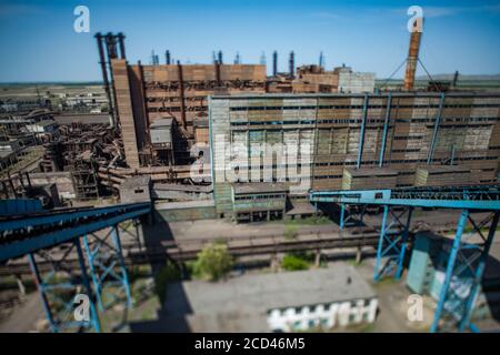 Verlassene sowjetische Metallurgie Fabrikgebäude und verrostete Kamine auf blauem Himmel. Foto ist Vogelperspektive mit Tilt-Shift-Effekt Objektiv. Teilweise verschwommen. Tara Stockfoto