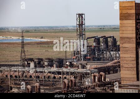 Alte verlassene sowjetische Metallurgie Fabrikgebäude und Rohrleitungen und verrostete Kamine auf blauem Himmel und Steppenhintergrund. Taraz Stadt, Kasachstan Stockfoto