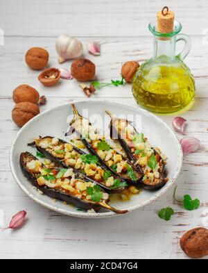 Gebackene Aubergine mit Olivenöl, Knoblauch, Petersilie oder Koriander (Koriander) Walnüssen und Semmelbröseln. Mediterraner Gemüsesnack in einer weißen Plate Stockfoto