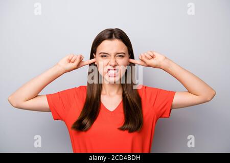 Nahaufnahme Porträt von ihr sie schön attraktiv böse verrückt deprimiert Gerade haarige Mädchen tragen orange T-Shirt schließen Ohren Grimacing Vermeidung von Lärm Stockfoto