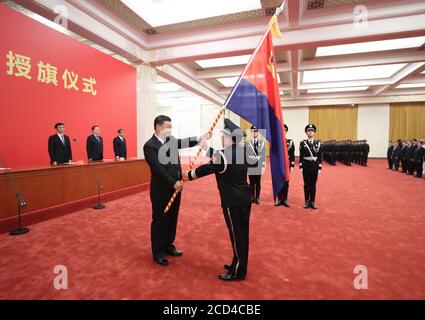 Peking, China. August 2020. Der chinesische Präsident Xi Jinping, auch Generalsekretär des Zentralkomitees der Kommunistischen Partei Chinas und Vorsitzender der Zentralen Militärkommission, übergibt Chinas Polizeikräfte während einer Zeremonie in der Großen Halle des Volkes in Peking, der Hauptstadt Chinas, am 26. August 2020 die Polizeiflagge. Quelle: Ju Peng/Xinhua/Alamy Live News Stockfoto