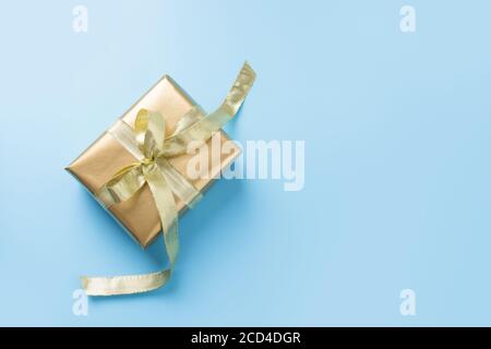 Luxus goldene Geschenkbox auf blauem Hintergrund. Flach liegend. Blick von oben. Stockfoto