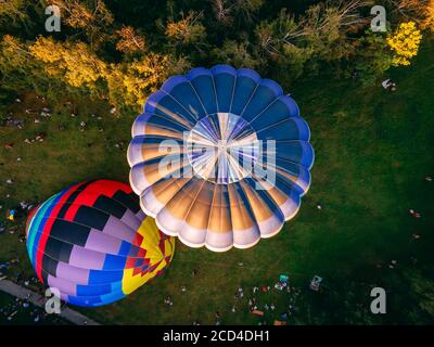 Heißluftballons bereiten sich für einen frühen Start aus dem Park in der kleinen europäischen Stadt, Region Kiew, Ukraine Stockfoto