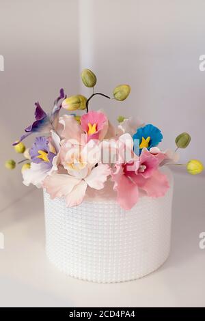 Elegante Blumendekoration für einen Hochzeitstorte, mit königlicher Vereisung und symmetrisch positionierten Zuckerperlen überzogen, mit essbaren Zuckerpastenrosen Stockfoto