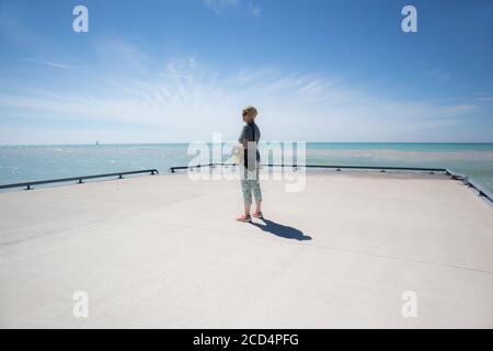 Frau am Ende des Piers starrte die Unermesslichkeit. Stockfoto