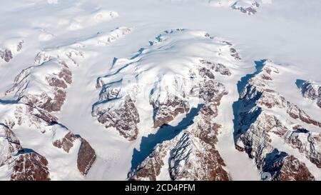 Luftaufnahme der gefrorenen Landschaft mit Gletschern, Flüssen und Eisbergen an der Südküste Grönlands aus dem Fenster eines Flugzeugs Stockfoto