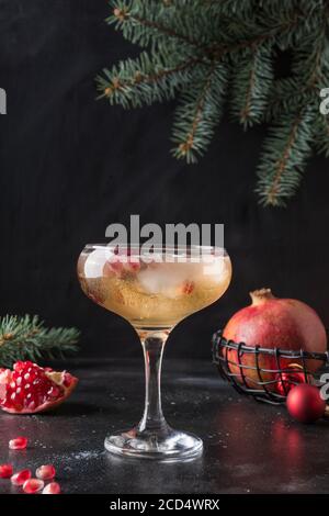 Granatapfel Cocktail aus Sekt, Preiselbeeren garnieren Rosmarin auf schwarz. Stockfoto