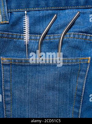 Nachhaltigkeitskonzept. Jeans-Tasche mit Trinkhalmen aus Edelstahl und Reinigungsbürste. Wiederverwendbare Trinkhalme. Nachhaltiger Lebensstil. Umweltfreundliche Produkte. Stockfoto