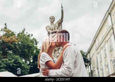 Junges Paar in der Liebe küssen in alten Lviv Stadt von Brunnen Statue tragen traditionelle ukrainische Hemden. Stockfoto