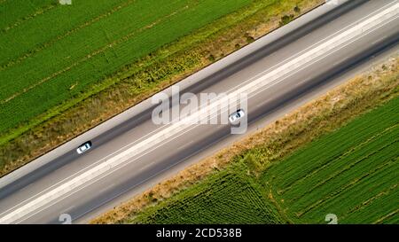 Straßen- und Reisekonzept, Luftaufnahme der Straße durch Felder Stockfoto